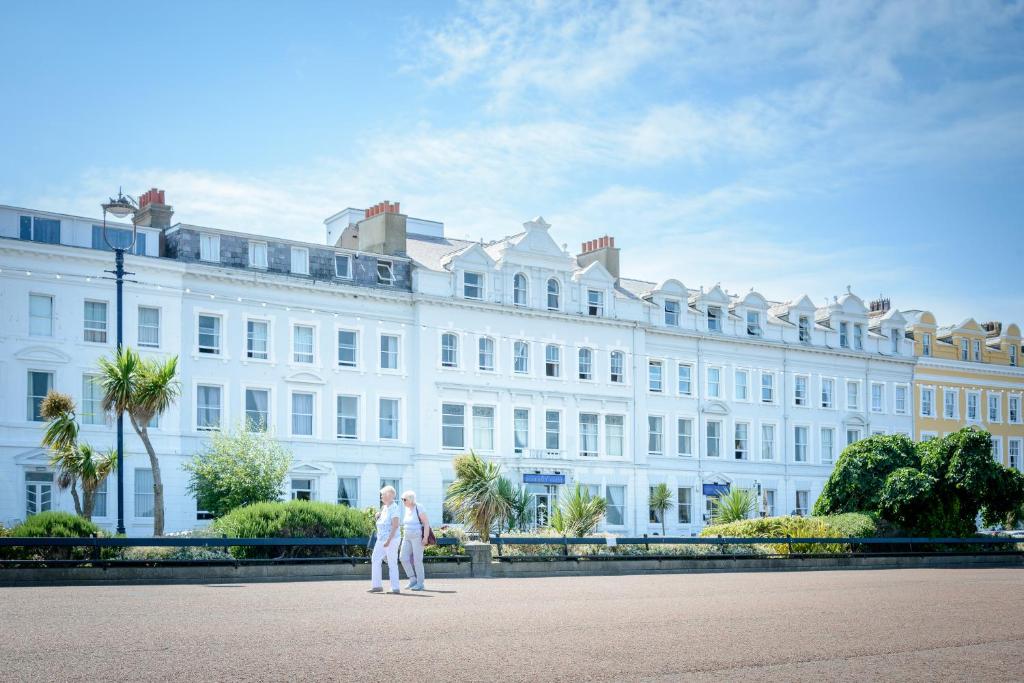 a couple walking in front of a large white building at Somerset Hotel in Llandudno