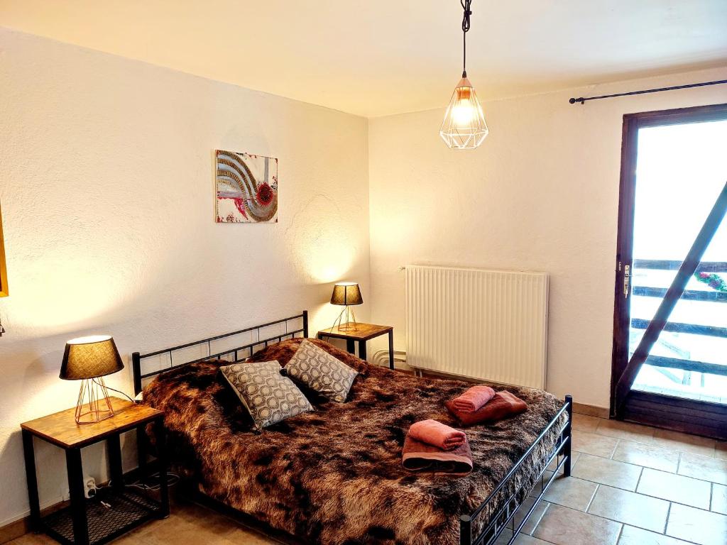 a bedroom with a bed with two lamps and a window at Õ 2040 Chambre Flocon in Saint-Véran