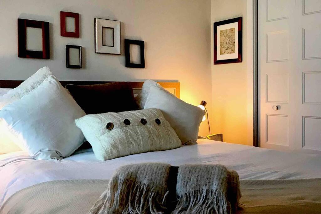 1 dormitorio con cama blanca y almohadas blancas en Condo entier, fully equiped pool and Spa only in summer, en Mont-Tremblant