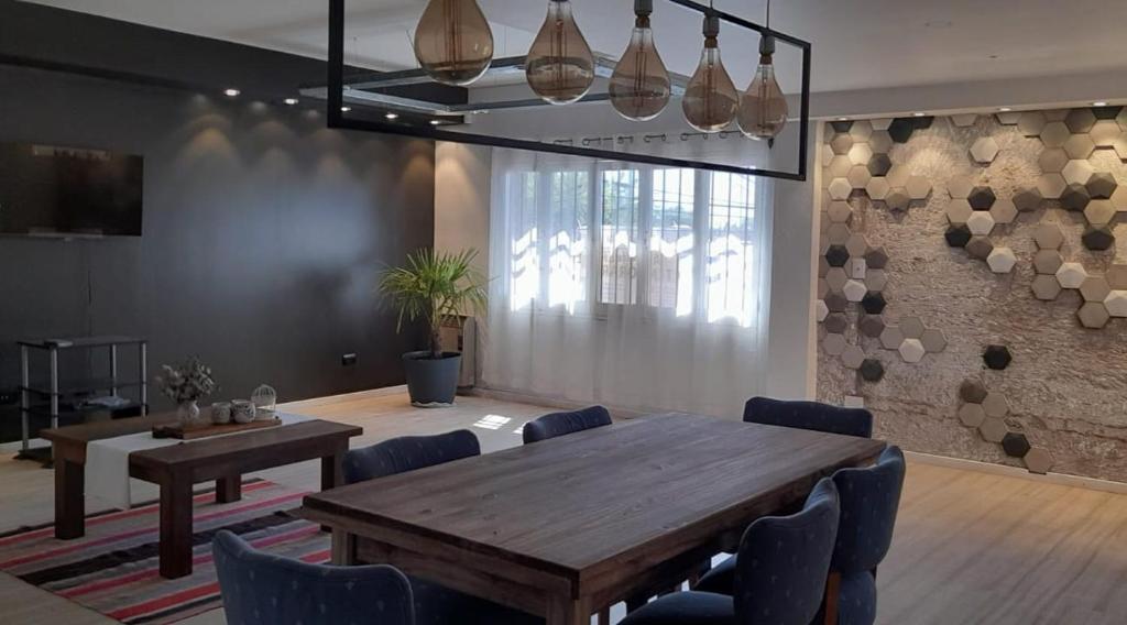 a dining room with a wooden table and chairs at Departamento céntrico en San Martín, amplio, con aire acondicionado y cochera privada in San Martín