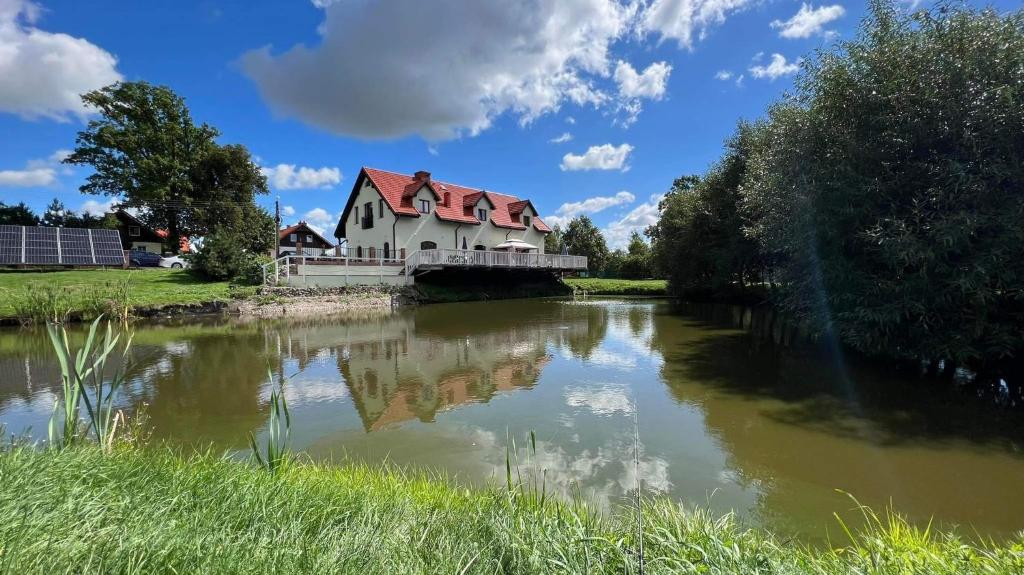 una casa sentada en un puente sobre un río en Czar Mamry Apartamenty, en Węgorzewo