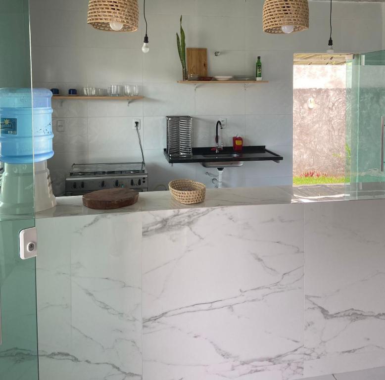 a kitchen with white marble counter tops and a sink at Casa Arembepe in Camaçari