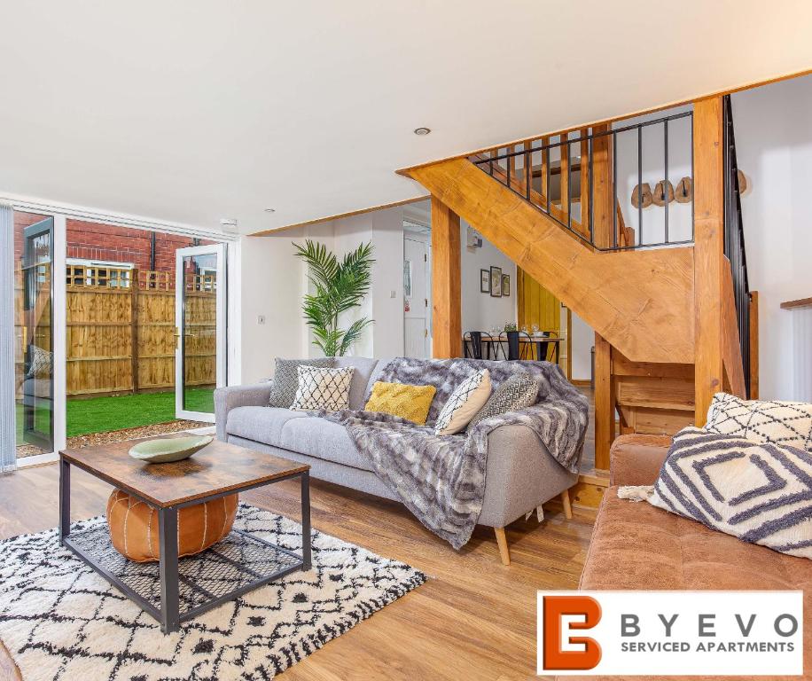 a living room with a couch and a staircase at ByEvo Oswestry Barn - Quirky romantic retreat or cosy contractor base in Oswestry