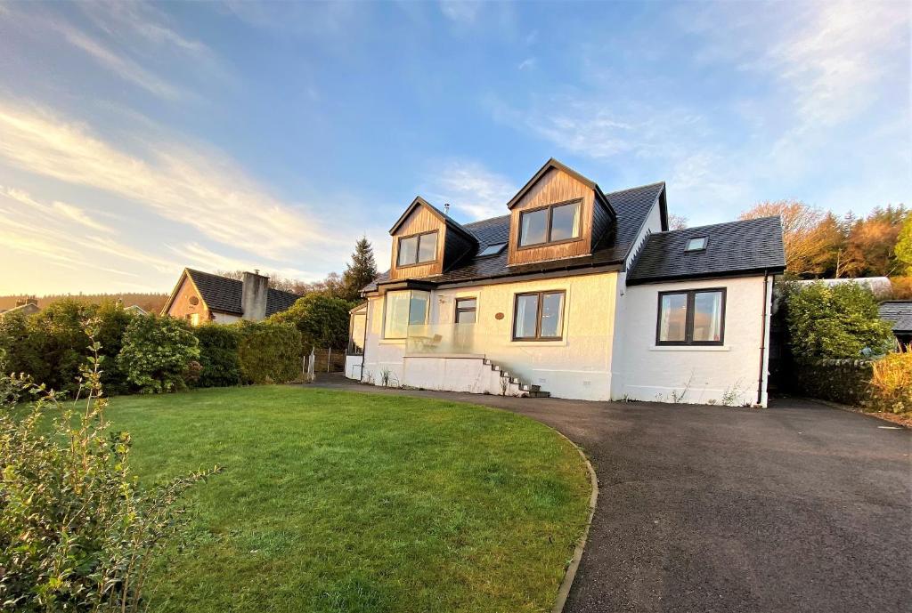 a large white house with a driveway at The Neuk in Tighnabruaich