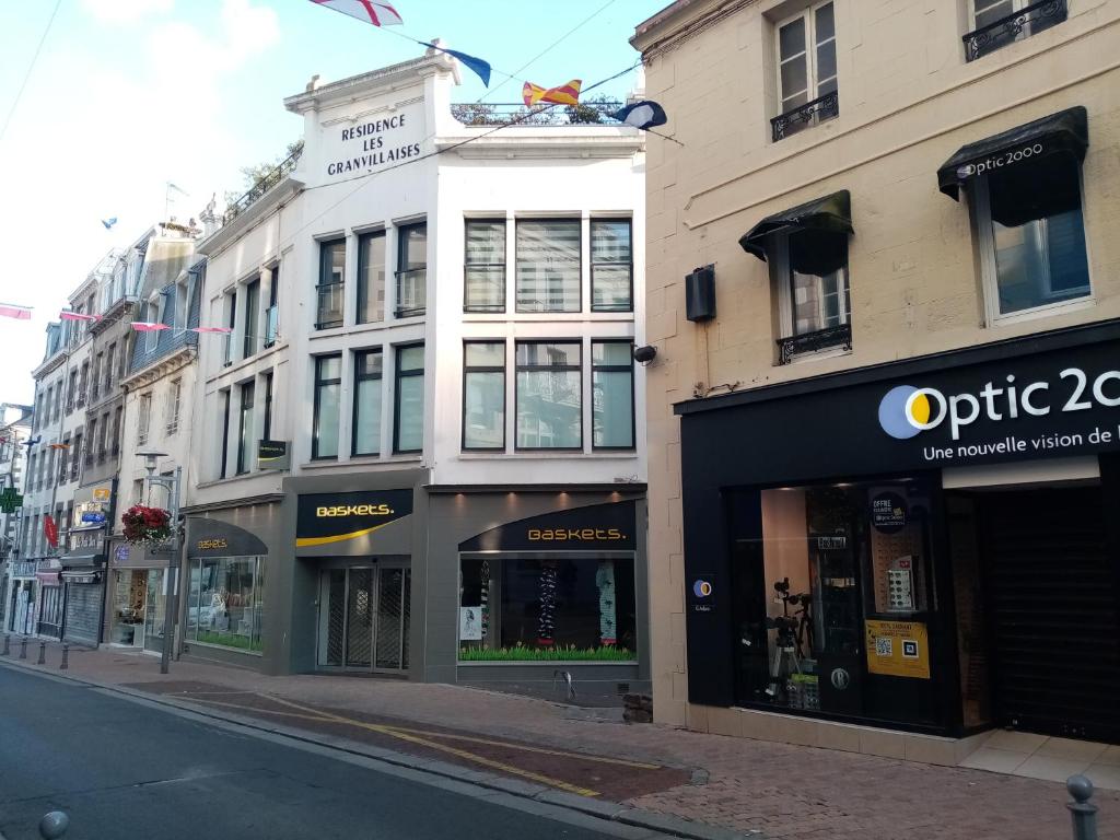 a row of buildings on a city street at Les granvillaises in Granville