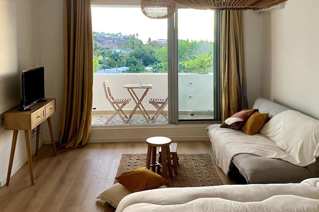 - un salon avec un canapé et une grande fenêtre dans l'établissement Studio au coeur de St Gilles à 5min de la plage, à Saint-Gilles les Bains