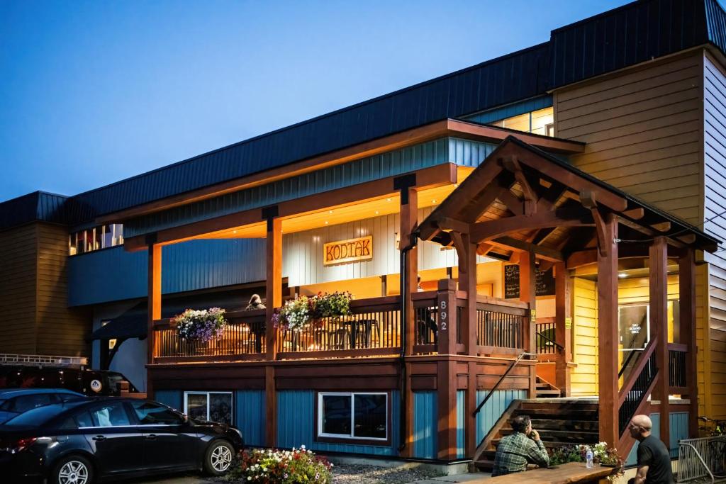 a house with a balcony and a car parked in front at The Raging Elk Adventure Lodging in Fernie