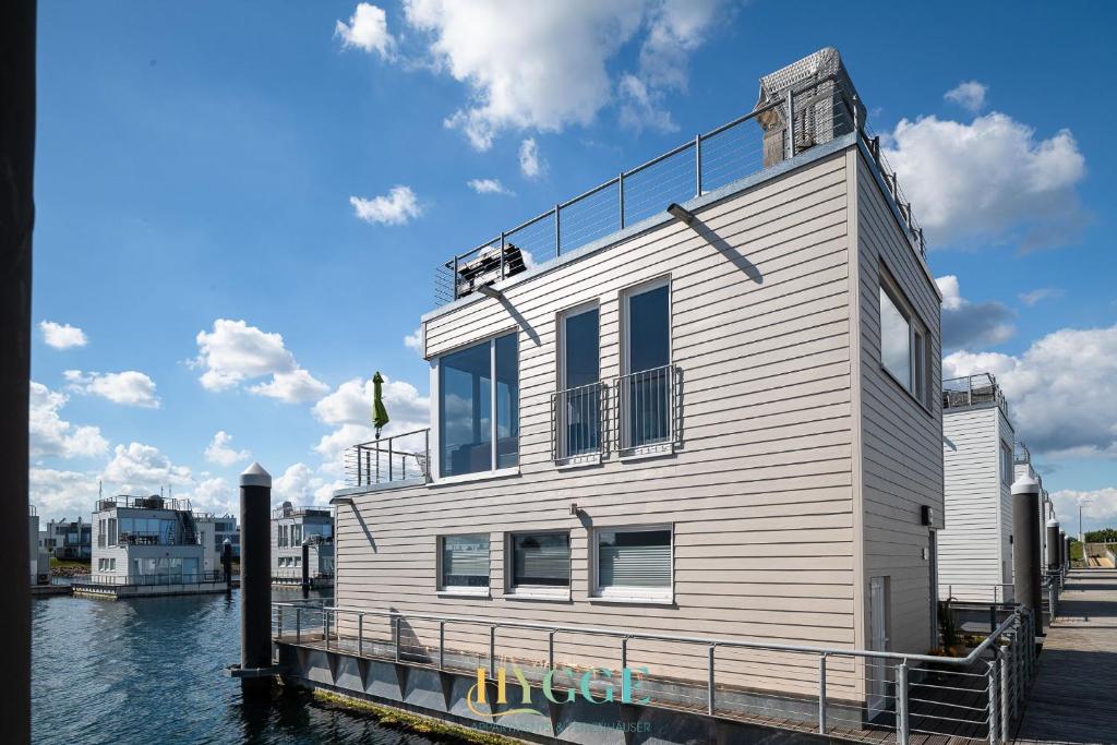 a building on a dock in the water at Schwimmendes Haus Hygge Olpenitz in Olpenitz