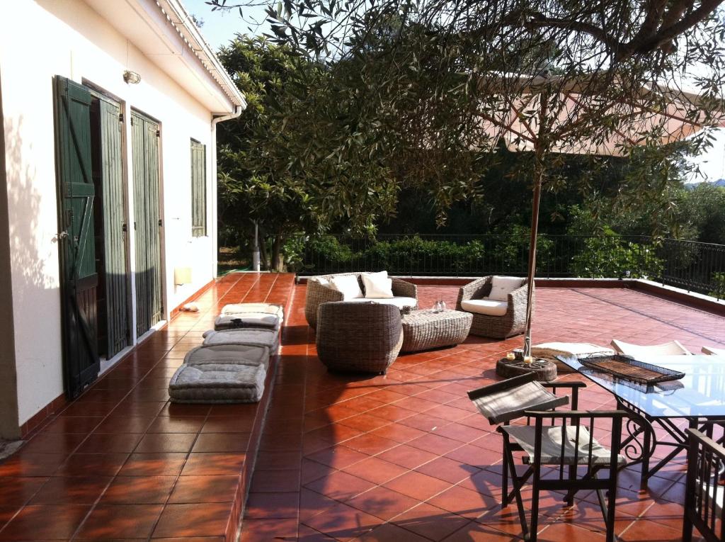 a patio with couches and a table and chairs at Corfu Cottage Sfrayda in Sinarádes