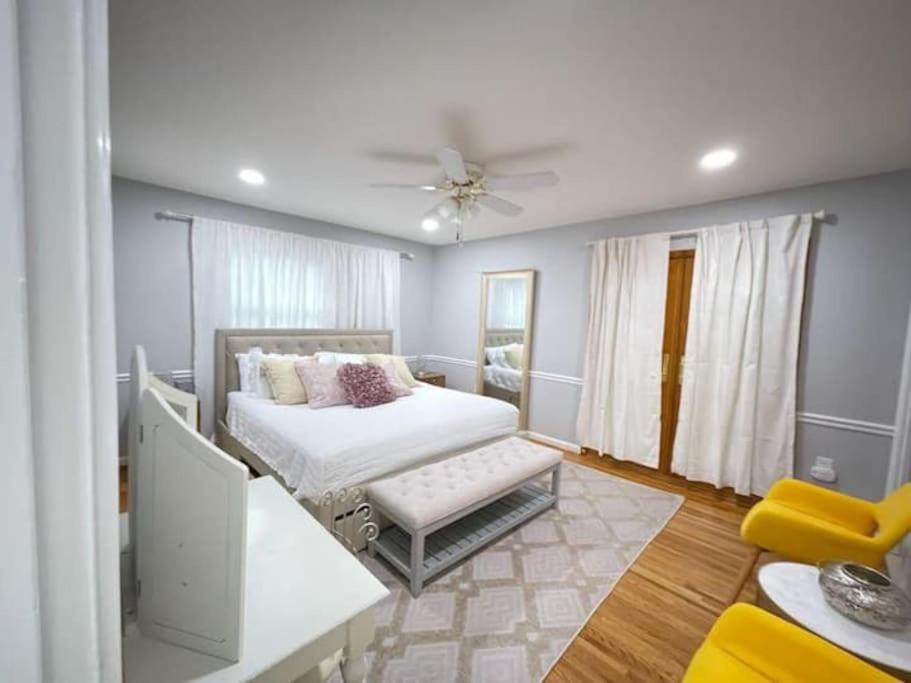 1 dormitorio con 1 cama y 1 silla en Lux Family Xcape with HotTub Fireplace Deck BBQ en Silver Spring
