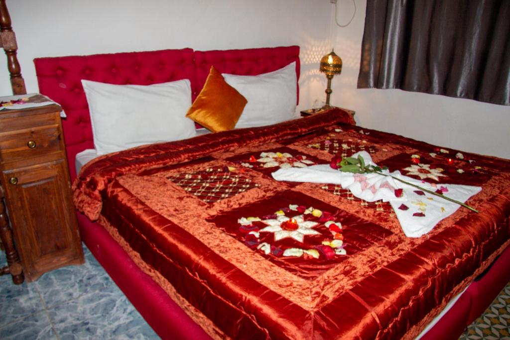 a bedroom with a red bed with a red blanket at Riad Baba in Fez