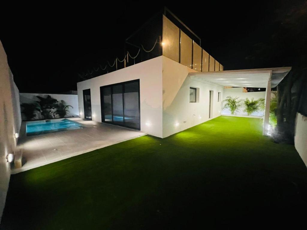 an empty house with a green lawn at night at Cap-Canaria FKK in San Bartolomé de Tirajana