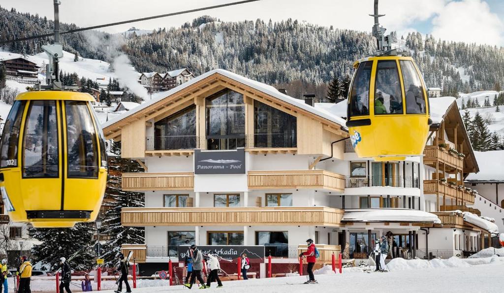 due impianti di risalita di fronte a un rifugio sciistico di Hotel Arkadia - "Adults Only" a Corvara in Badia