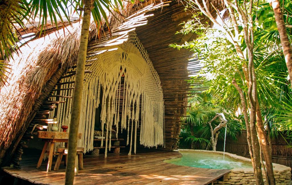 a resort with a pool and a building with trees at Ikal Tulum Hotel in Tulum