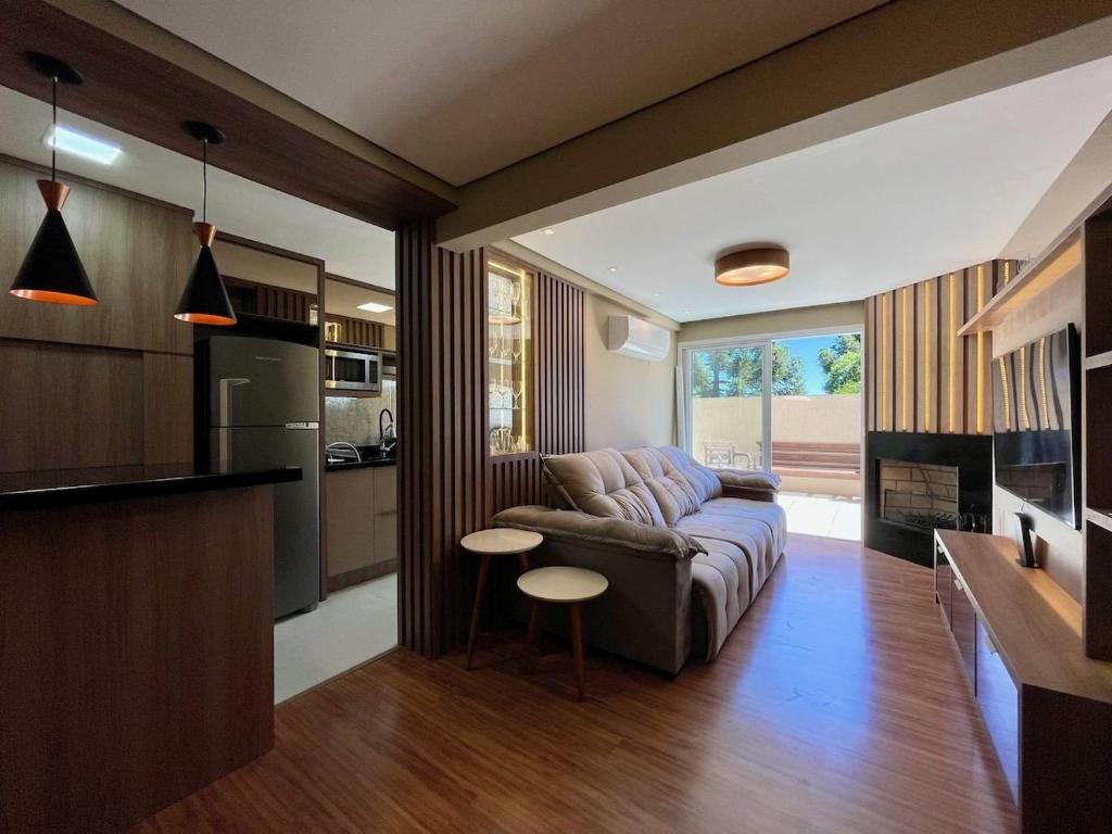 sala de estar con sofá y cocina en Apartamento 2 dorm e VARANDA a 3 QD RUA COBERTA, en Canela