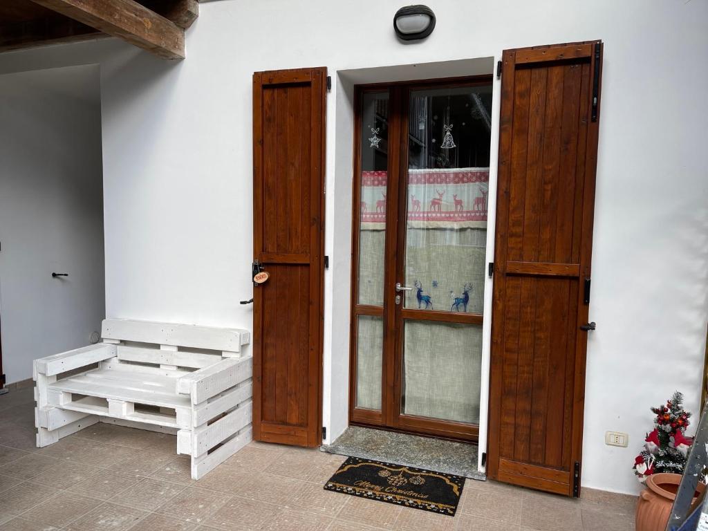 an entrance to a building with a door and a bench at Appartamento vista Monte Rosa, giardino in Residence Walser a 10minuti da Macugnaga - MONTEROSAFLAT in Vanzone