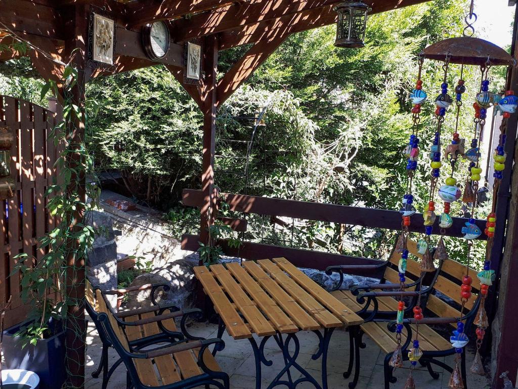 a wooden bench and two chairs under a gazebo at Amber Cottage in Matlock