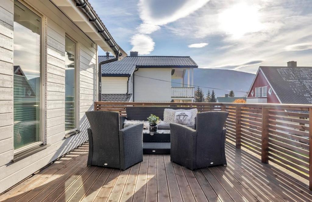 a deck with chairs and a table on a house at Polar Arctic Luxury House - Free parking in Tromsø