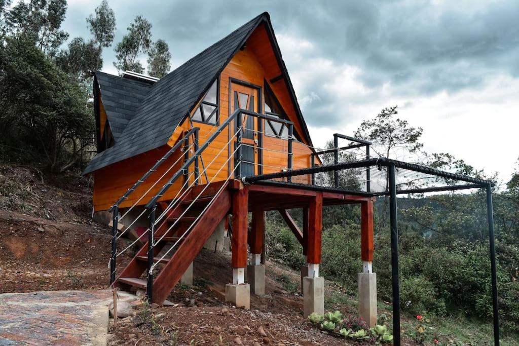 una casa con una escalera que conduce a ella en Glamping refugio Gaia, en Paipa