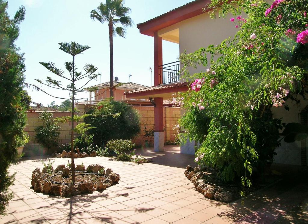 una casa con un patio con un jardín con flores en RELAX, PLAYA, NATURALEZA…!!. VILLA INDEPENDIENTE CON JARDÍN... en Islantilla