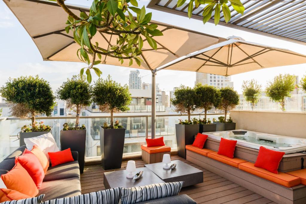 a rooftop patio with furniture and potted plants at Luxe 3BR Penthouse w Jacuzzi&Parking&Mamad by HolyGuest in Tel Aviv