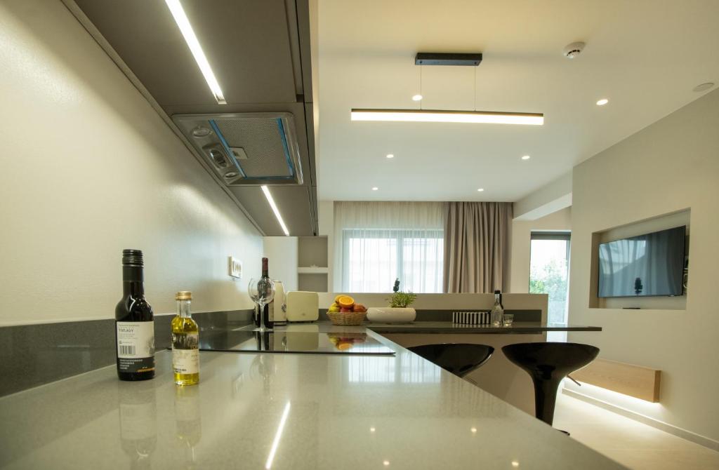 Celine Luxury Apartments & Suites في آغيوس نيكولاوس: مطبخ مع طاولة مع زجاجتين من النبيذ