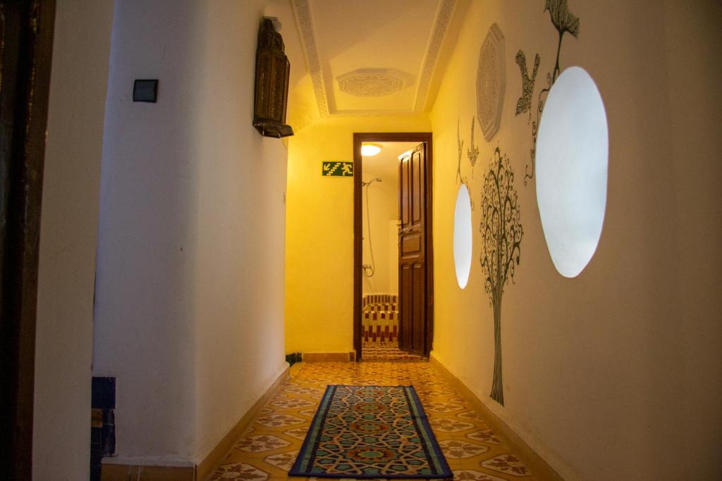 a hallway with a yellow door and a tile floor at Riad Baba in Fez