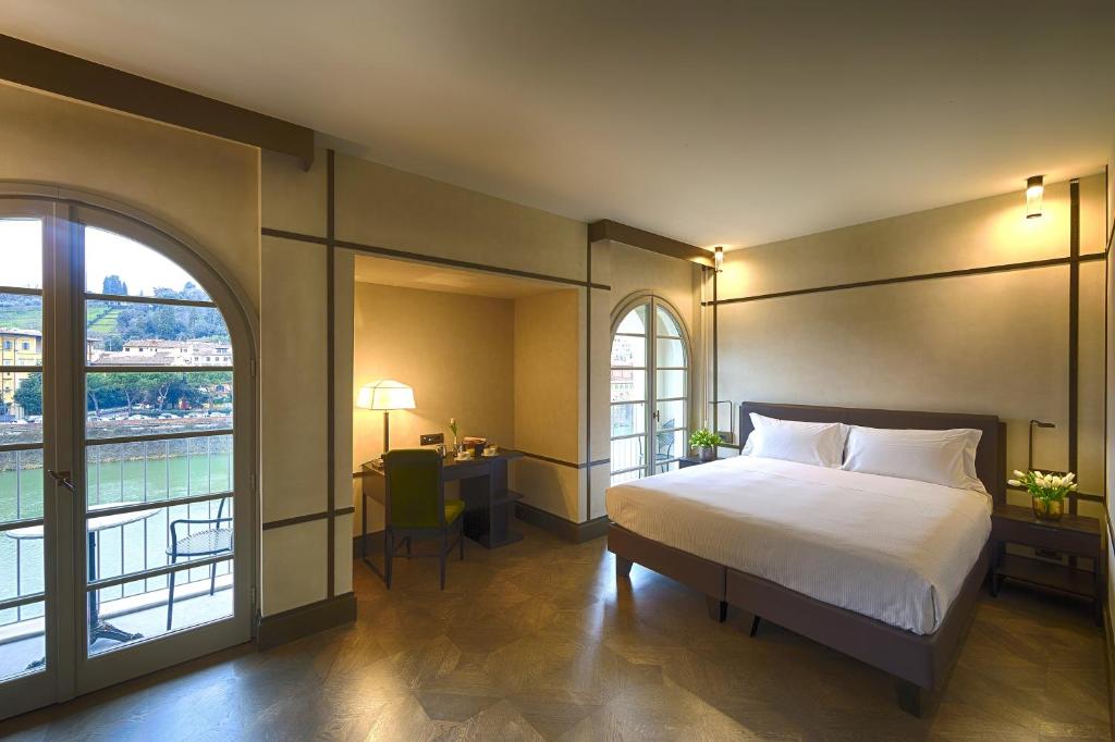 a bedroom with a bed and a large window at Hotel Balestri - WTB Hotels in Florence