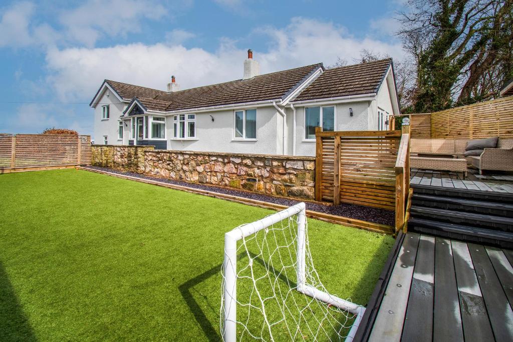 a soccer ball on a field in front of a house at Pen-y-Coed ⥈ Modern ⥈ Hot Tub ⥈ Beautiful Views in Abergele