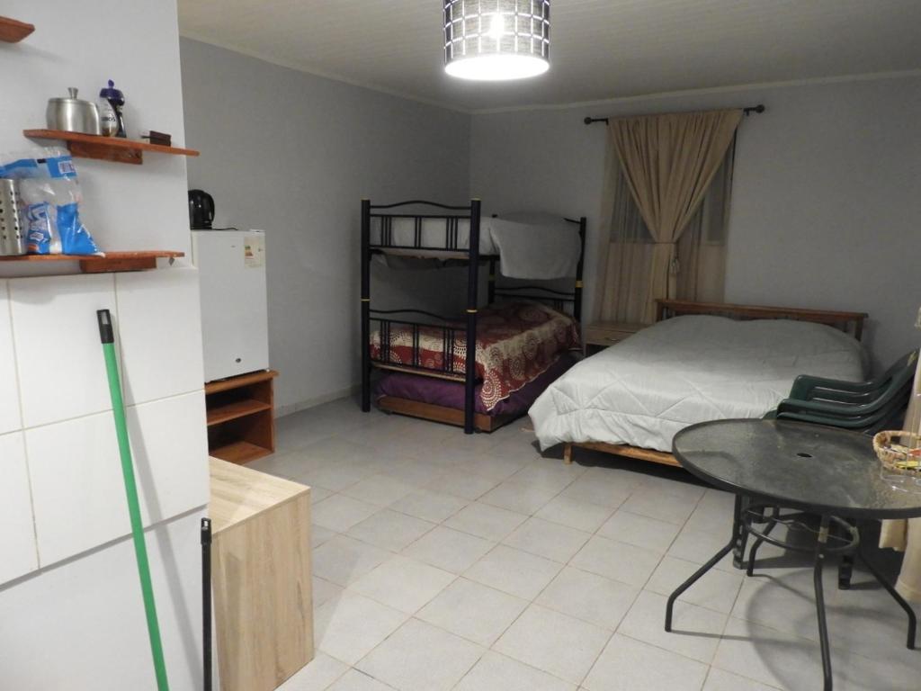 Cette chambre comprend un lit, une table et un réfrigérateur. dans l'établissement Hostal Ribera de Quitor, à San Pedro de Atacama