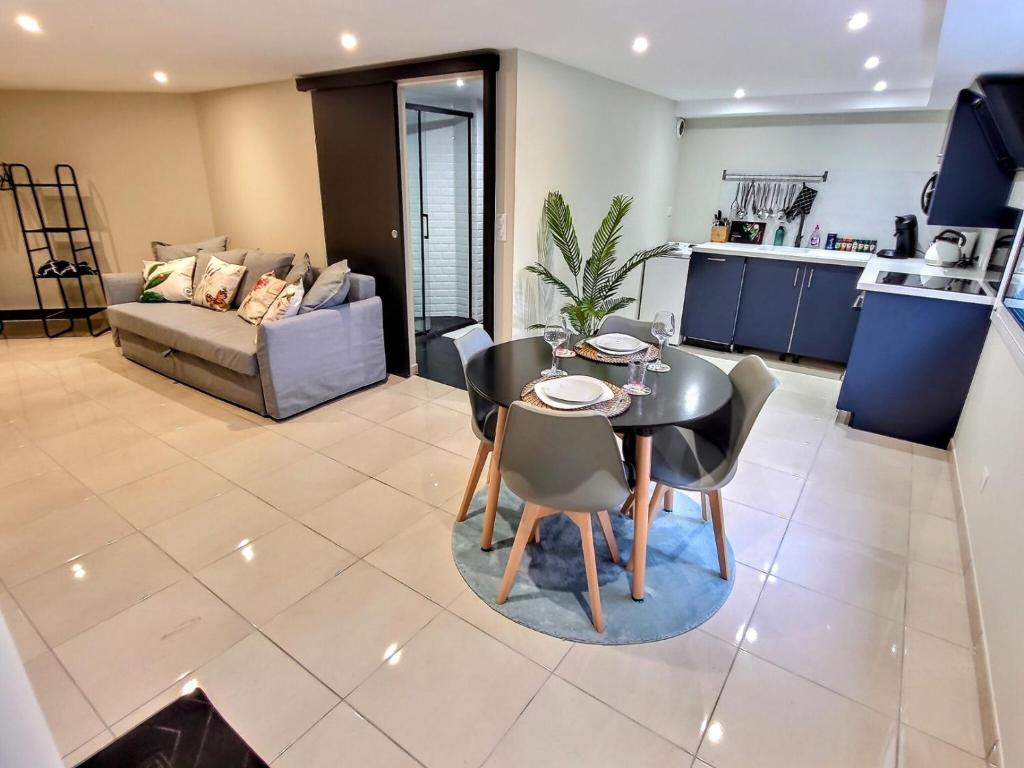 a kitchen and a living room with a table and chairs at Le Petit Rocher 30m2- Studio standing 3 étoiles in Saint-Aignan-Grand-Lieu