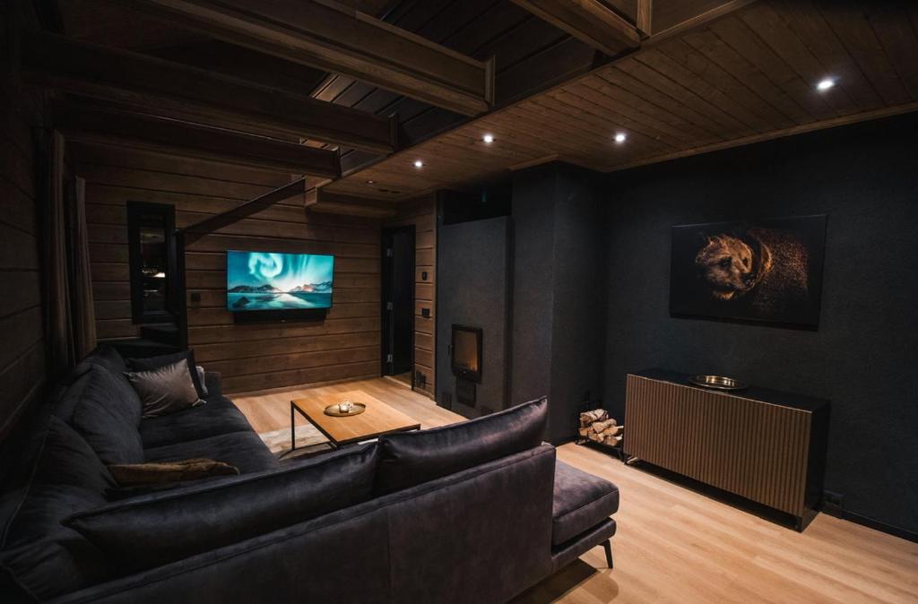 Una sala de estar con un sofá y un televisor de pantalla plana. en Le-Villa Black, en Levi