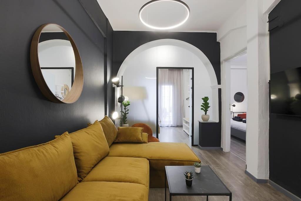 een woonkamer met een gele bank en een spiegel bij Ancient Agora Central Living in Thessaloniki