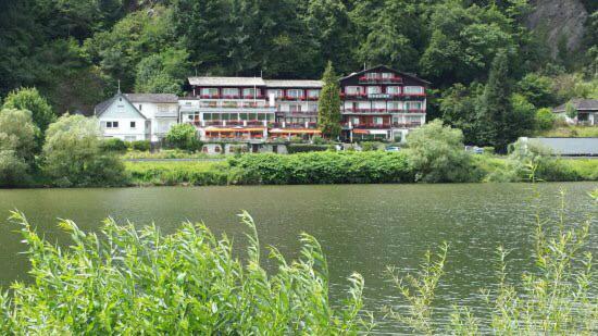 ein großes Gebäude neben einem großen Wasserkörper in der Unterkunft Hotel Gonzlay in Traben-Trarbach