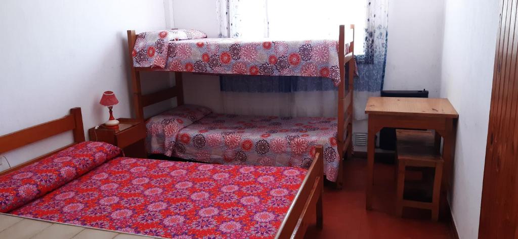 una camera con due letti a castello e un tavolo di Hostería Vecchia Costa a San Bernardo