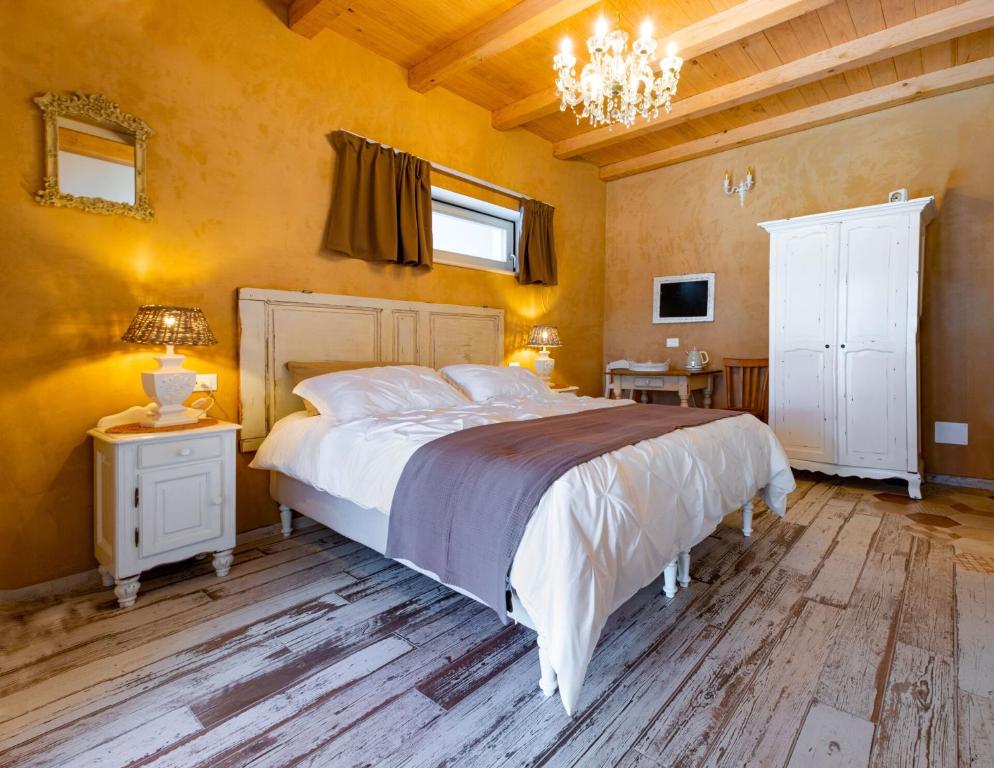 a bedroom with a large bed and a chandelier at Aria di Bosco in LʼAquila