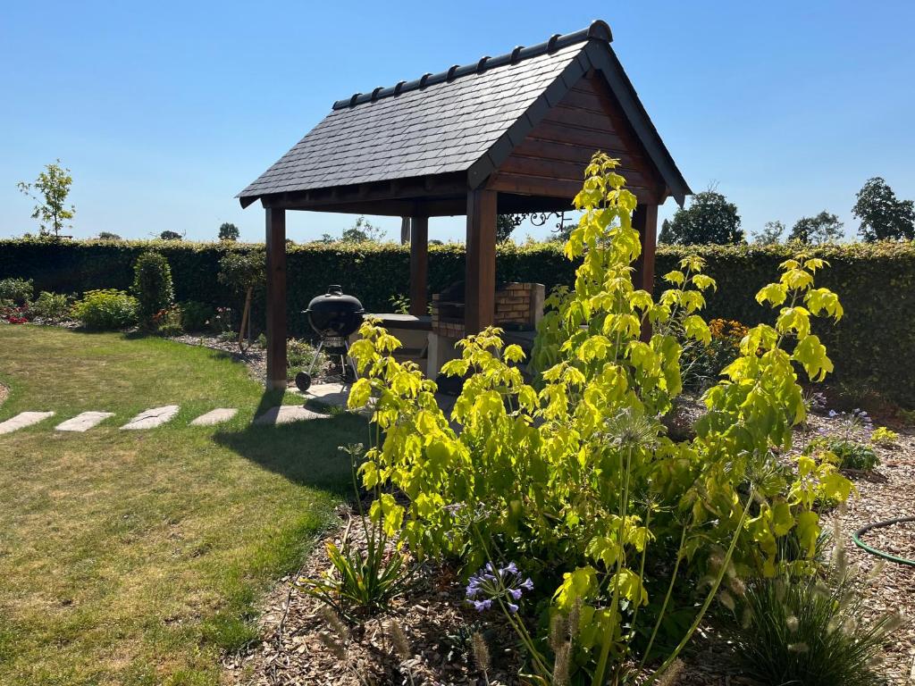 a gazebo in a garden with yellow flowers at Aurefees in Ellon