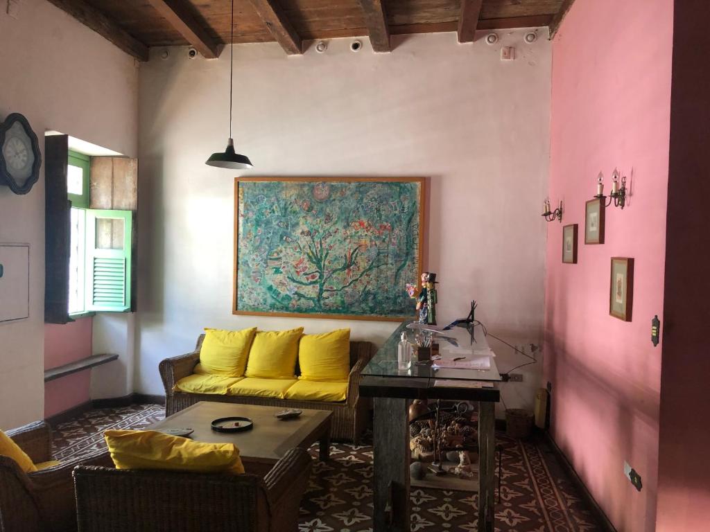 a living room with a yellow couch and a table at Pousada São Pedro in Olinda