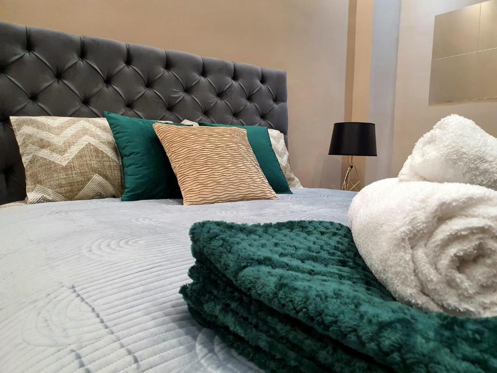 a bed with a green and white blanket on it at Emerald Apartment Belgrade in Senjak (historical)