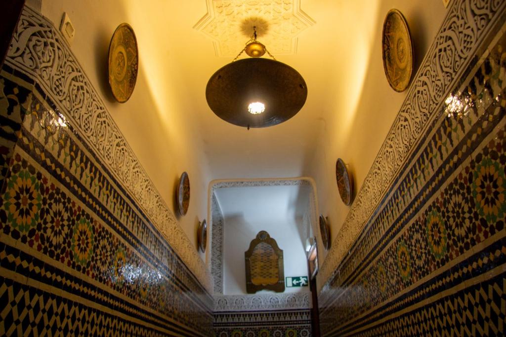 a hallway of a mosque with a ceiling and a chandelier at Riad Baba in Fez