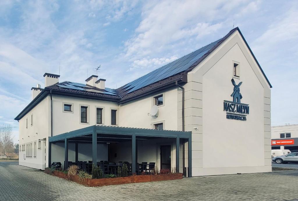 a white building with a kings inn sign on it at Nasz Młyn in Sufczyn