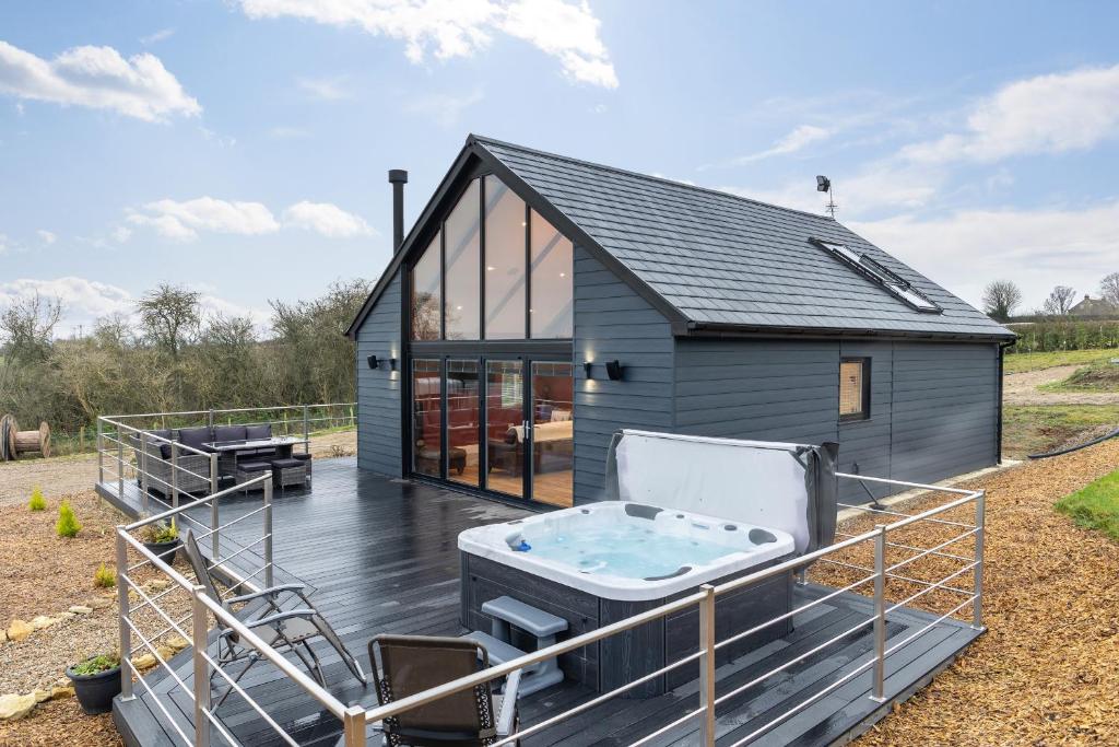 a tiny house with a hot tub on a deck at Stags Mount in Pickering