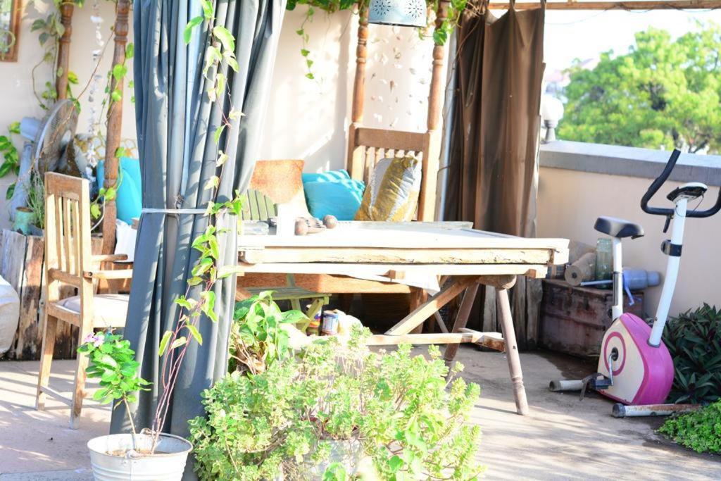 a patio with a table and chairs and plants at Sawa Sawa Apartment in Ngambo
