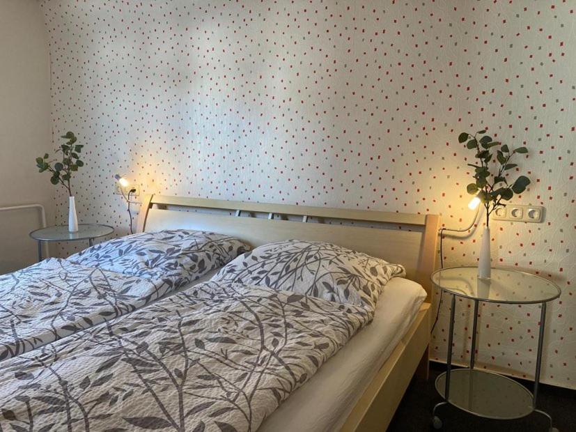 a bedroom with a bed and two tables with plants at Ferienwohnung Lukas in Frielendorf