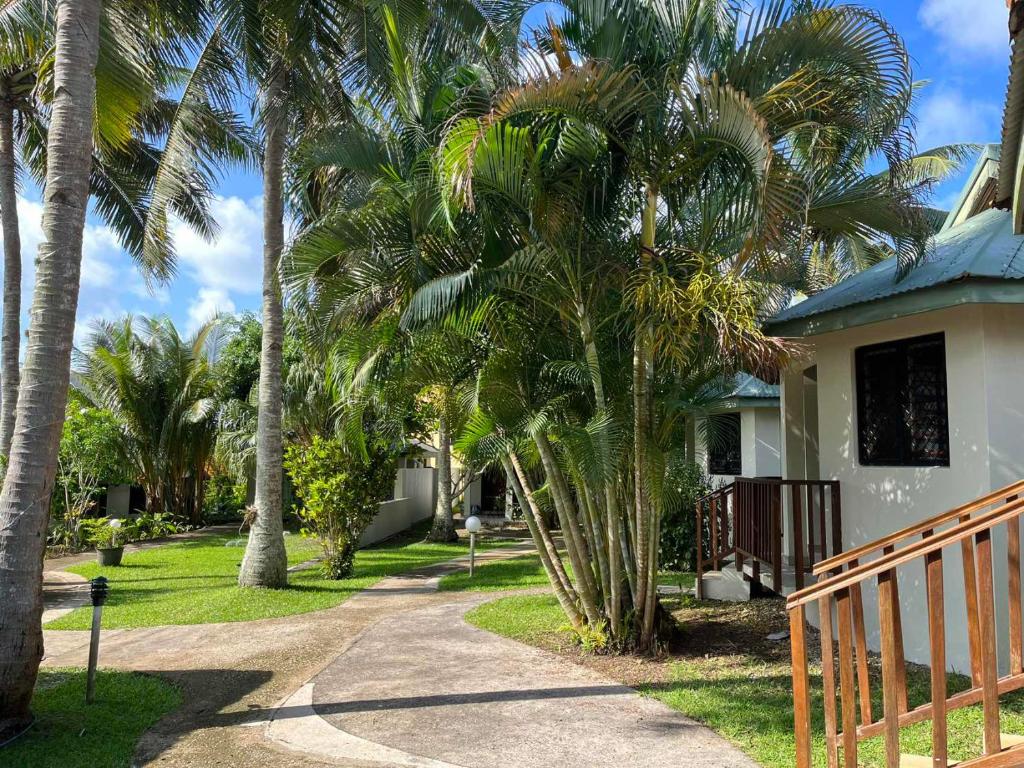 una casa con palmeras junto a una pasarela en TRADEWINDS VILLAS en Port Vila