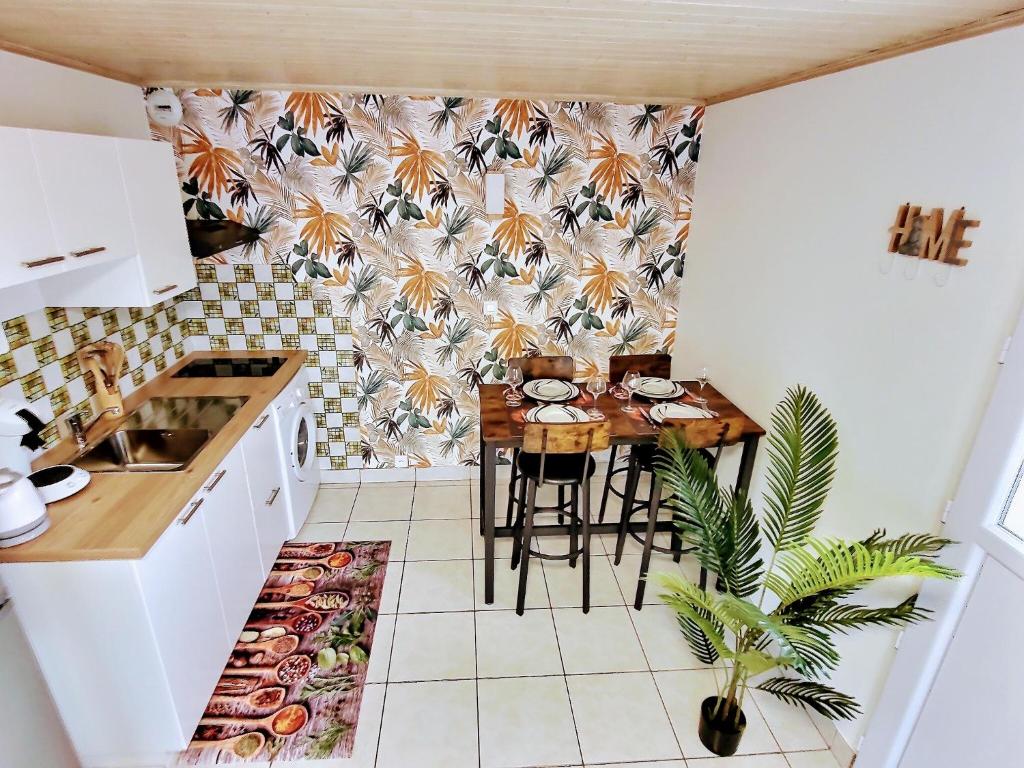 Into the Wild - T2 Cosy tout confort في بوغينايس: مطبخ صغير مع طاولة صغيرة في الغرفة