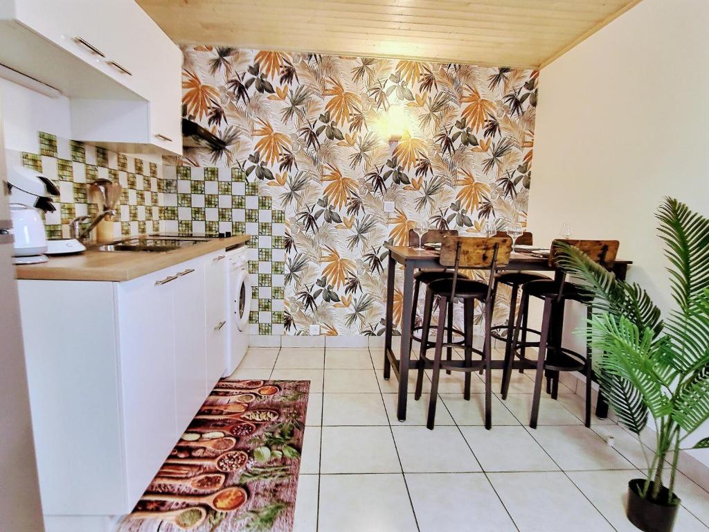 een keuken met een tafel en stoelen in een kamer bij Into the Wild - T2 Cosy tout confort in Bouguenais