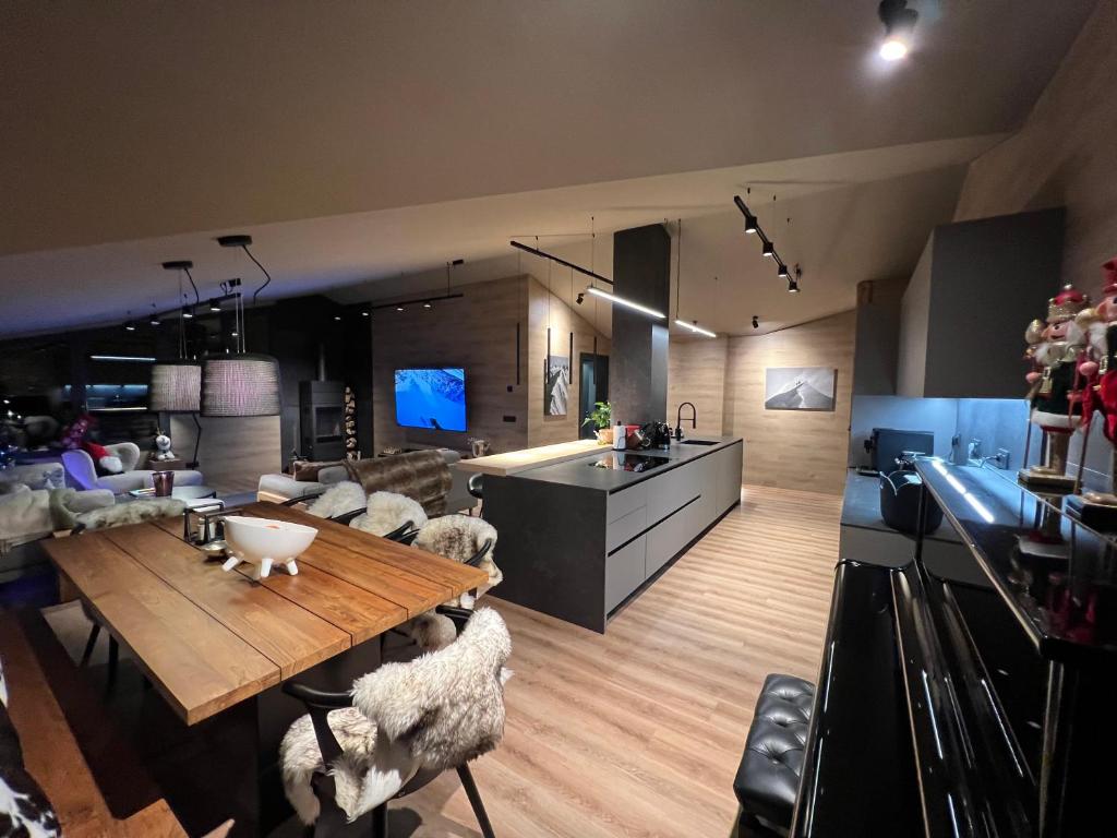 a living room with a wooden table and sheep chairs at Luxury Summit Penthouse - Soldeu - By Ski Chalet Andorra in Soldeu