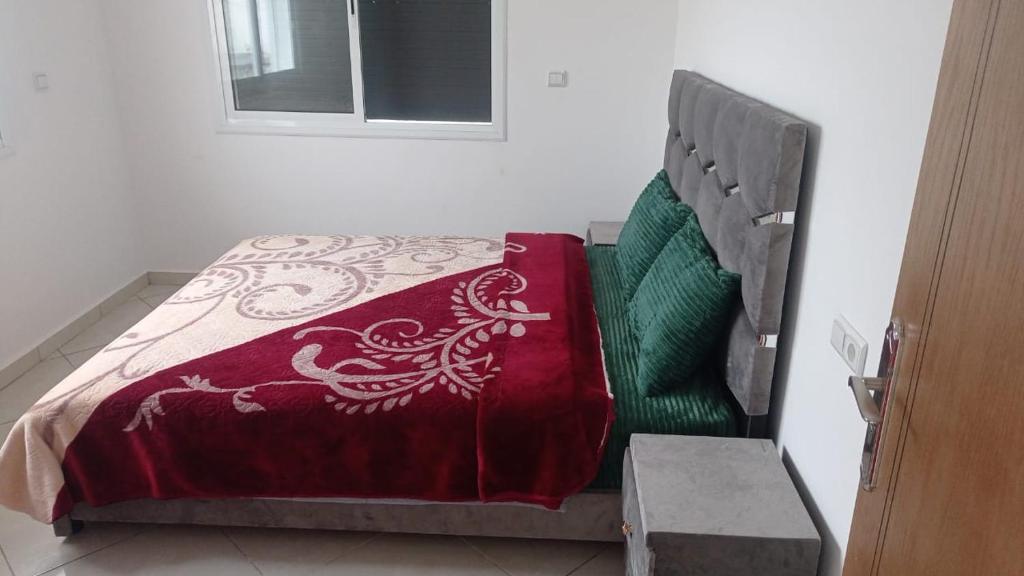 een bed met een rood en groen dekbed in een kamer bij Lovely View in Chefchaouene