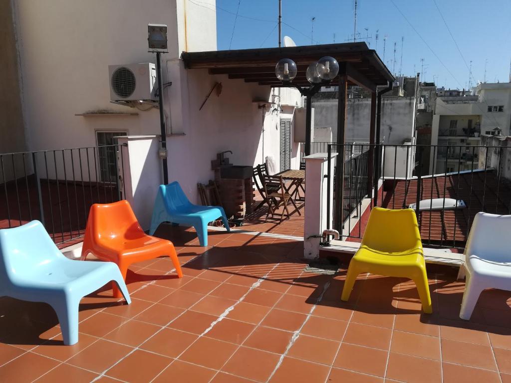 a group of colorful chairs sitting on a roof at Benedetto Cairoli Guest House in Bari